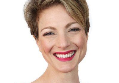 Smiling woman with short hair in a red top.