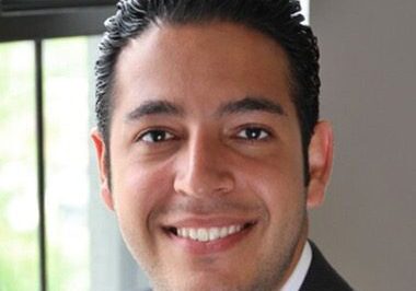 Smiling man in a suit indoors.