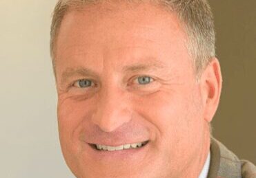 Smiling middle-aged man in a suit jacket.