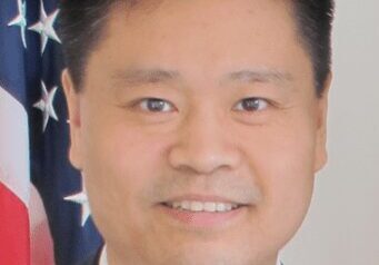 Portrait of a man in front of an American flag.