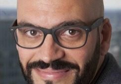 Smiling bald man with glasses and a beard.