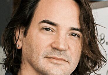 Portrait of a man with medium-length hair and a neutral expression.