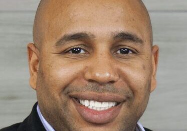 Portrait of a smiling man in a suit jacket.