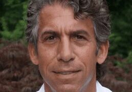 Portrait of a middle-aged man with gray hair and a slight smile.