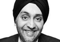 Smiling man wearing a turban and suit in a black and white photo.
