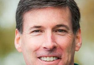 Portrait of a smiling middle-aged man with short dark hair.