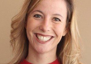 Smiling woman with blonde hair in a red top.