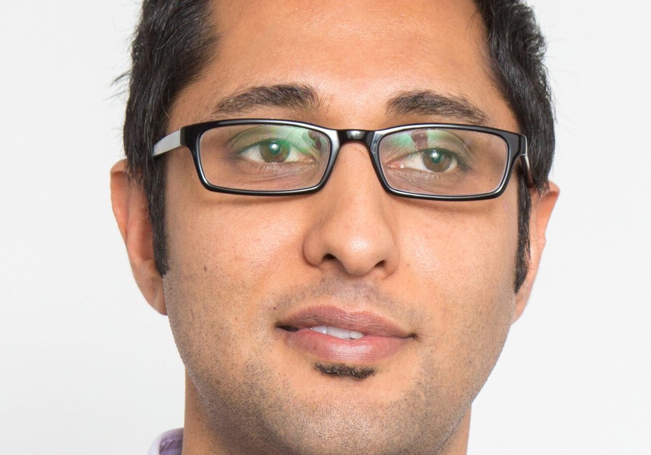 Portrait of a man wearing glasses with a slight smile.