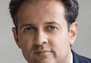 Portrait of a middle-aged man with dark hair in a suit.