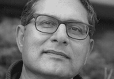 Portrait of a middle-aged man wearing glasses, looking at the camera.