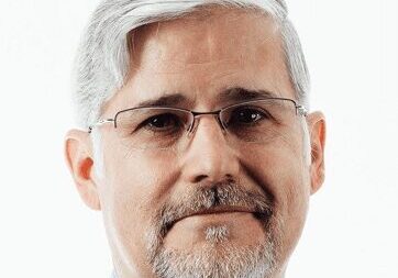 Portrait of a middle-aged man with gray hair and glasses.