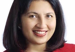 Portrait of a smiling woman with dark hair wearing a red top.